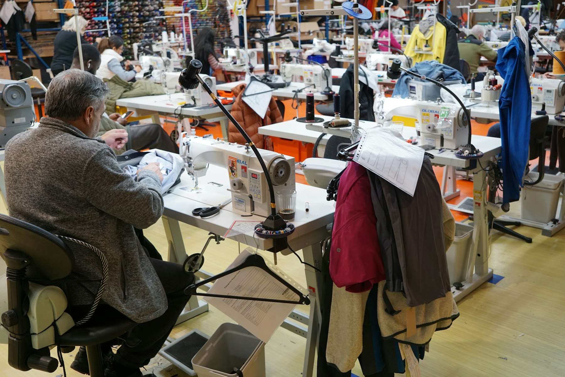 Craftsman stitching garments in our manufacturing workshop